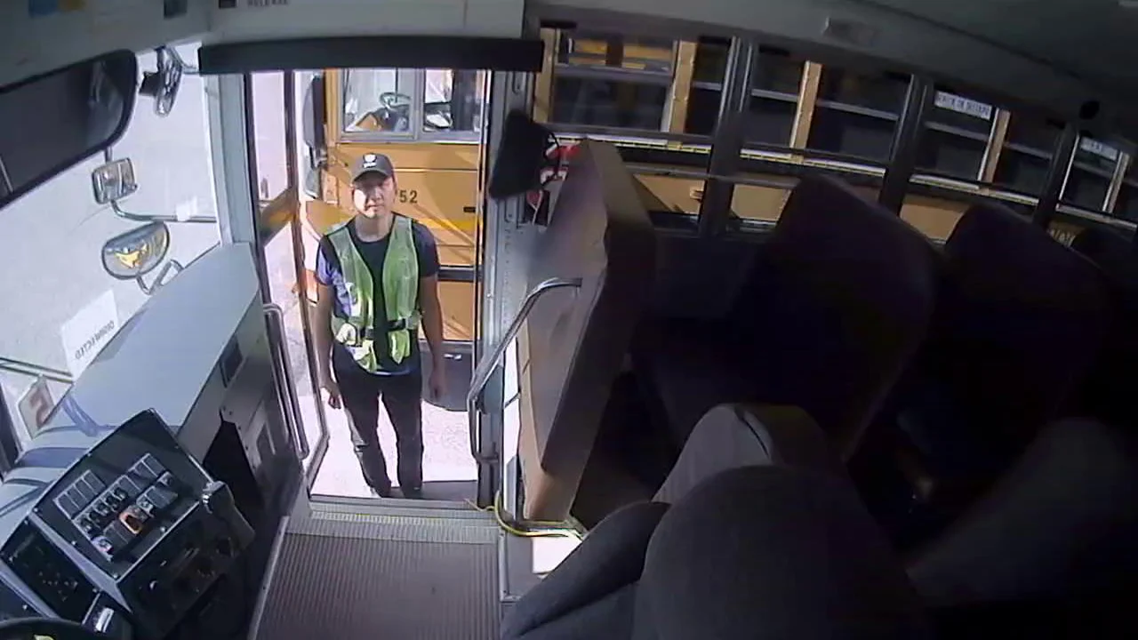 A2 | Safe Fleet Worker in a Reflective Safety Vest Stands at the Open Bus Door, Ready to Board or Assist Passengers Outside the Bus Entrance View from Inside the Bus Cabin.